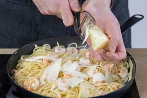 Manchego zu den Spaghetti mit Garnelen reiben