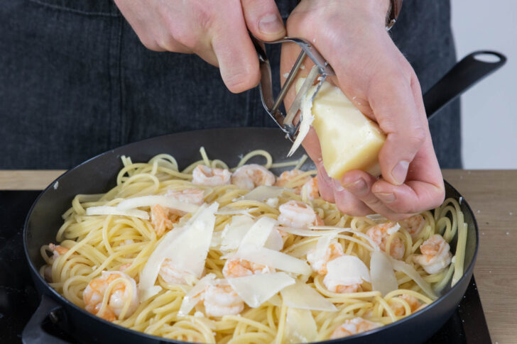 Manchego zu den Spaghetti mit Garnelen reiben