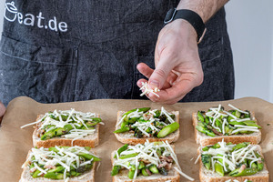 Streukäse auf den Toast geben