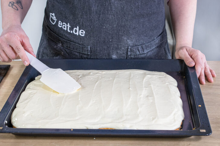 Creme auf dem Spiegeleikuchen verstreichen