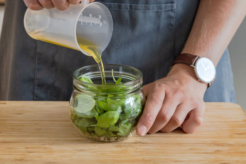Sonnenblumen- und Olivenöl in Glas geben
