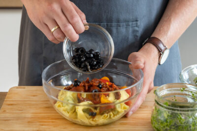 Olivenscheiben zu Salat geben