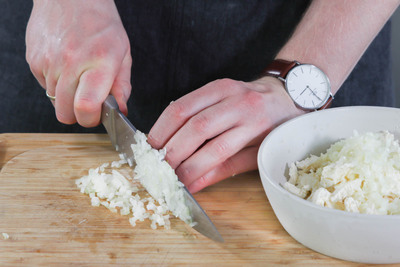 Zwiebeln und Knoblauch würfeln