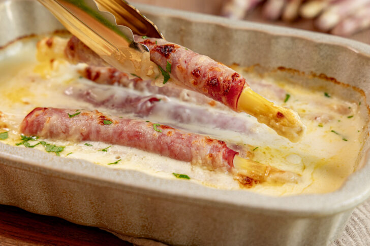 Überbackene Schinken-Spargel-Röllchen herausheben