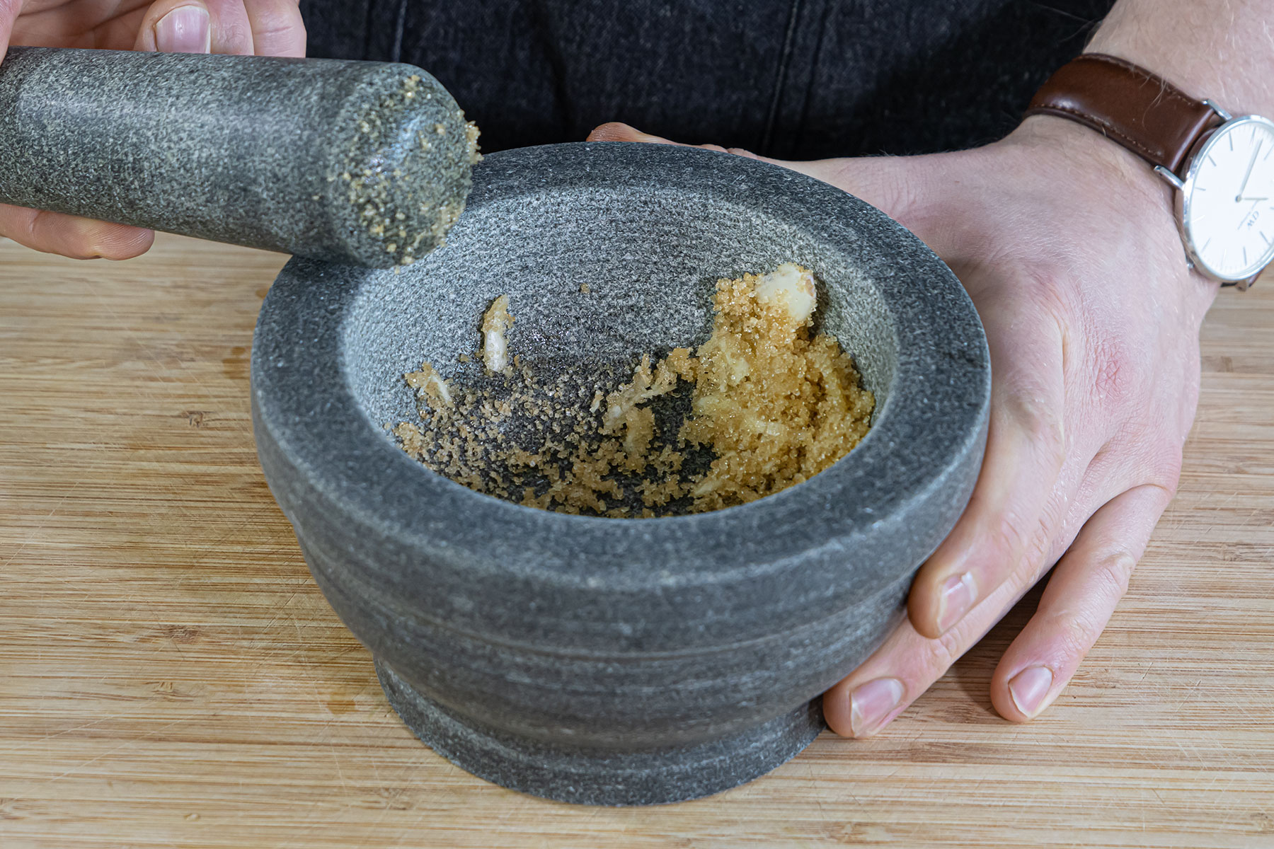 Knoblauch und Rohzucker mörsern