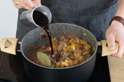 Rotwein zum Wiener Saftgulasch dazu gießen