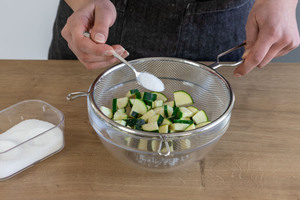 Geschnittene Zucchini mit Salz bestreuen und Flüssigkeit abtropfen lassen.