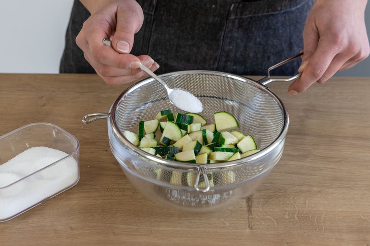 Geschnittene Zucchini mit Salz bestreuen und Flüssigkeit abtropfen lassen.