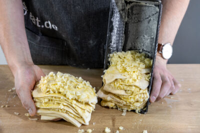 Käse-Knoblauch-Zupfbrot in die Kastenform schichten