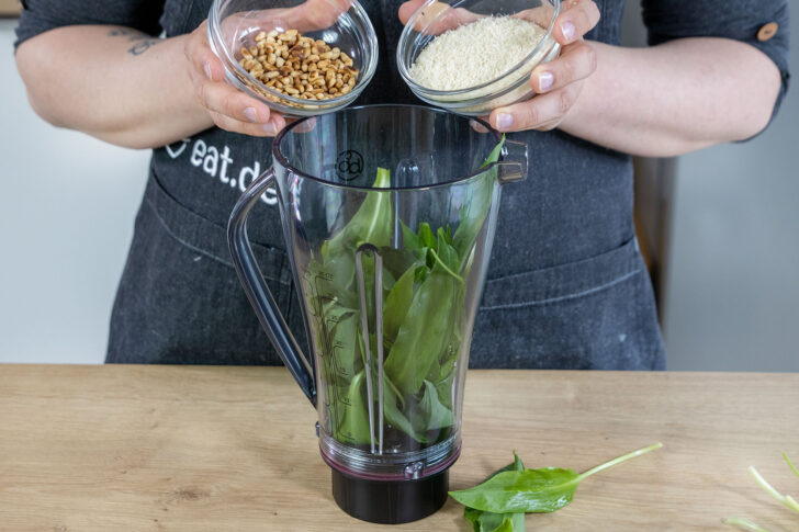 Parmesan und geröstete Pinienkerne mit in den Mixer geben