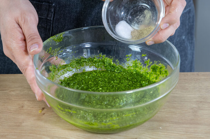 Pesto mit Salz und Pfeffer würzen