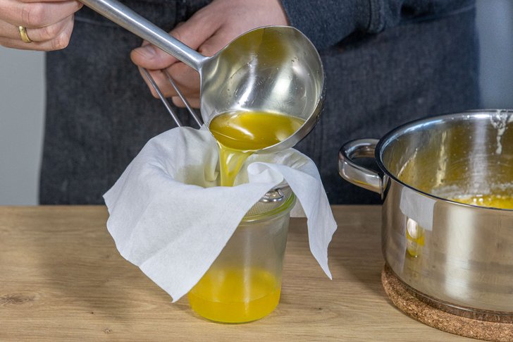 Butterschmalz durch ein Passiertuch gießen