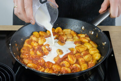 Sahne zu den Gnocchi gießen