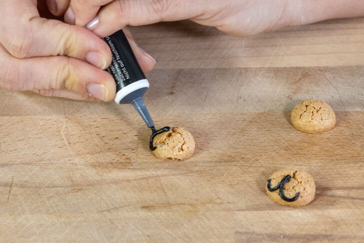 Mund auf Amarettini Keks mit Zuckerschrift malen