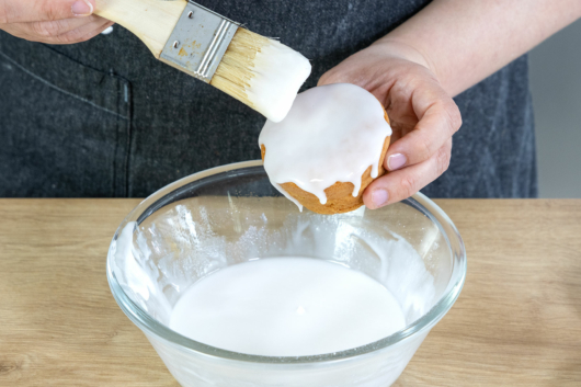 Helle Zuckerglasur auf Muffin für Kinder streichen