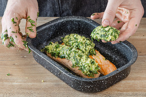 Bärlauchs Kruste auf dem Lachs verteilen