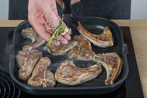 Rosmarin und Knoblauch in die Pfanne geben