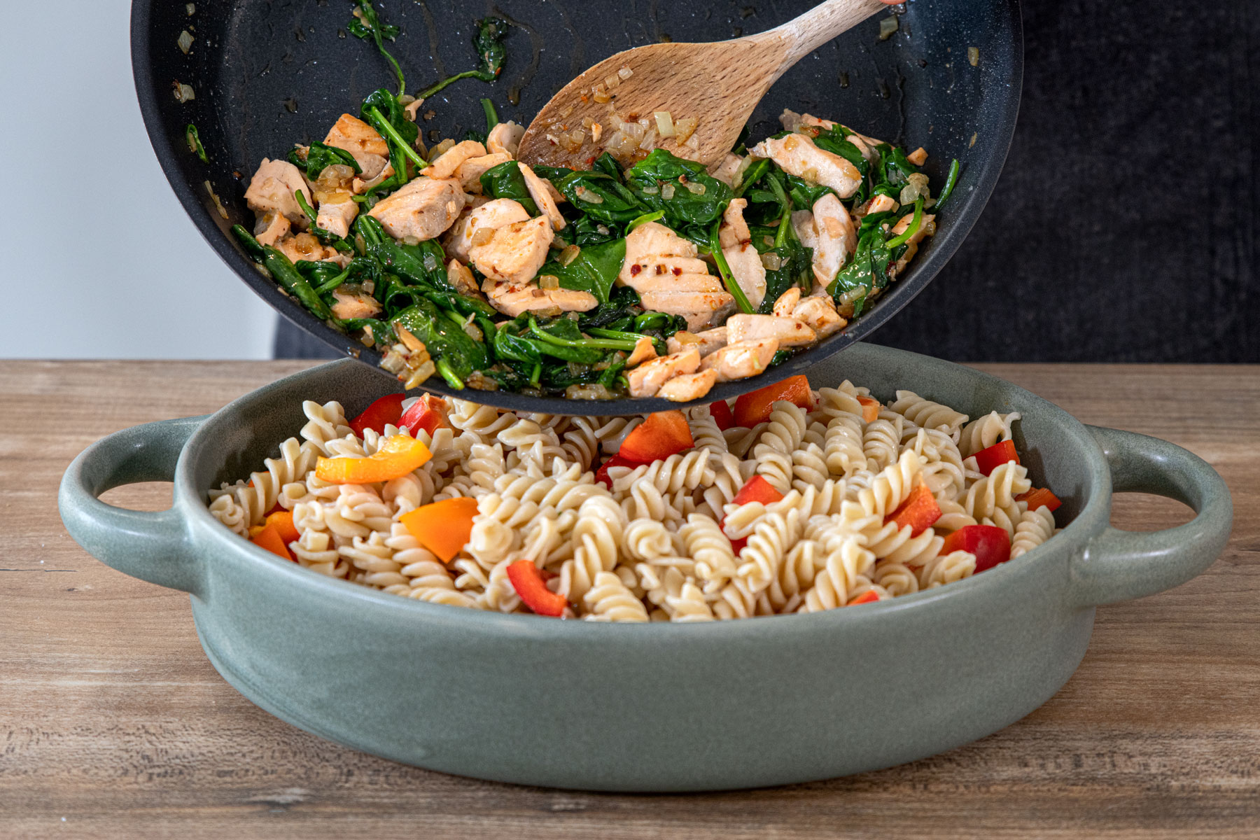 Lachs und Spinat zu den Nudeln geben