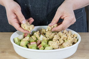 Streusel auf dem Rhabarber verteilen