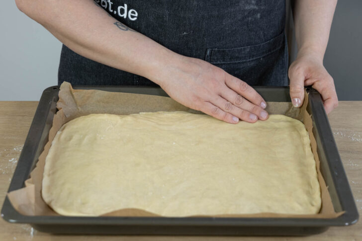 Hefeteig auf ein Blech geben