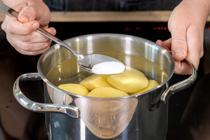 Salz zu den Kartoffeln geben