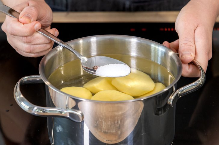 Salz zu den Kartoffeln geben