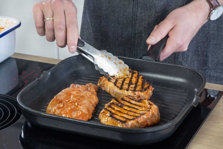 Marinierte Schweinerückensteaks wenden