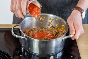 gehackte Tomaten zur italienischen Bolognese geben