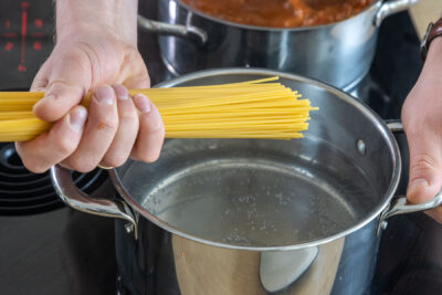 Spaghetti in das Wasser geben