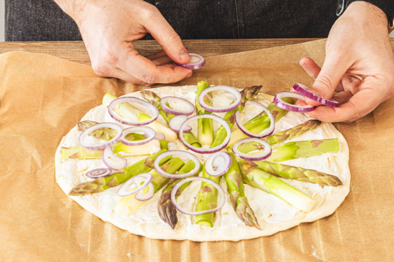 Spargelpizza mit Zwiebel belegen