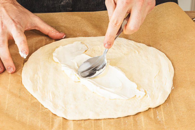 Teig mit Crème Fraîche bestreichen