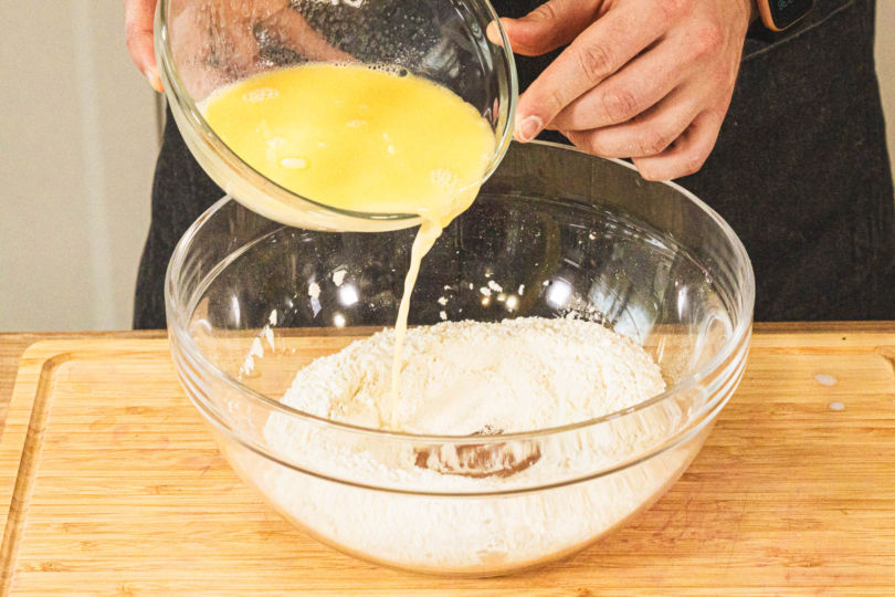 Milch-Butter zum Mehl in die Schüssel gießen