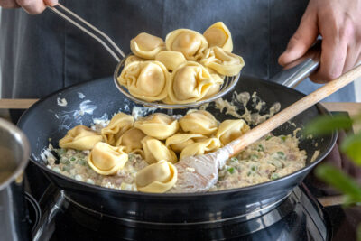 Tortellini zur Käse-Sahne-Soße geben