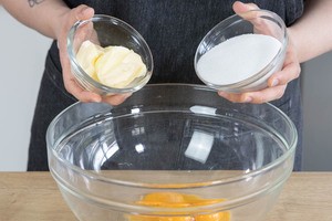 Butter und Zucker zu dem Eigelb geben