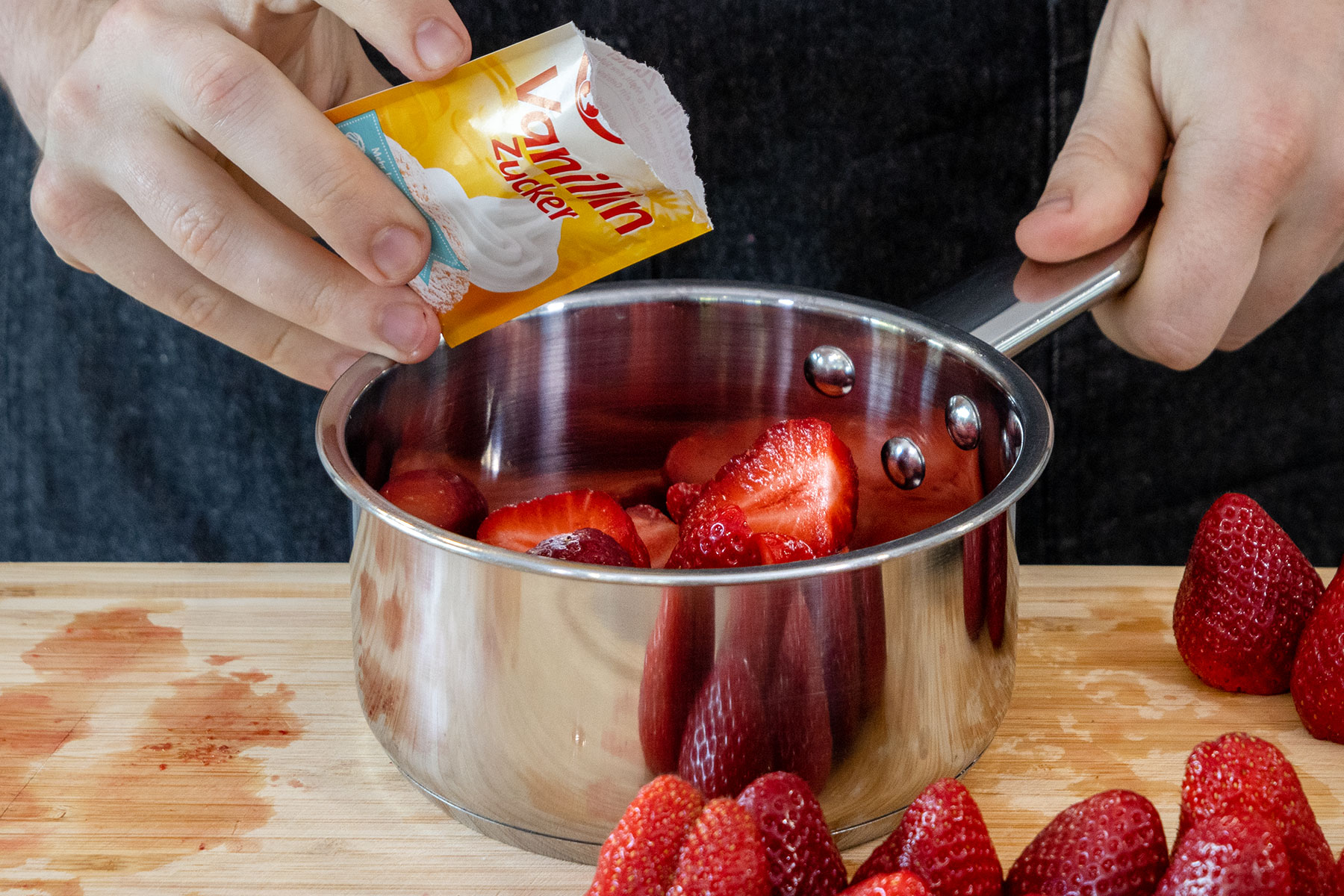 Vanillezucker mit Erdbeeren in einen Topf geben