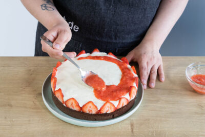 Erdbeermus auf der Torte verstreichen