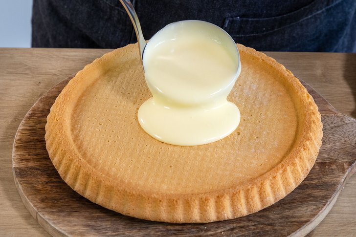 Puddingcreme auf dem Biskuitboden verteilen
