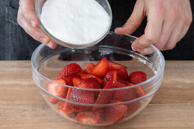 Zucker zu den Erdbeeren geben