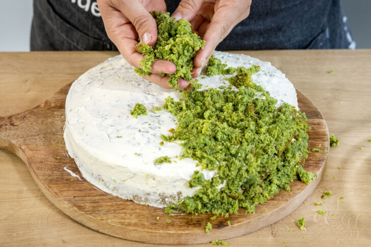Kuchen mit Creme beschmieren und die Kuchenbrösel darüber geben