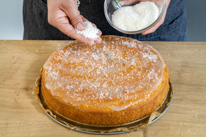Kokosstreusel auf den Kokoskuchen ohne Buttermilch streuen
