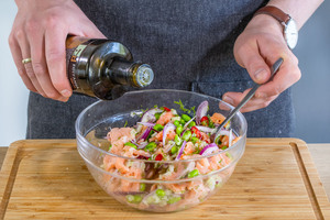 Olivenöl über Lachs-Ceviche geben