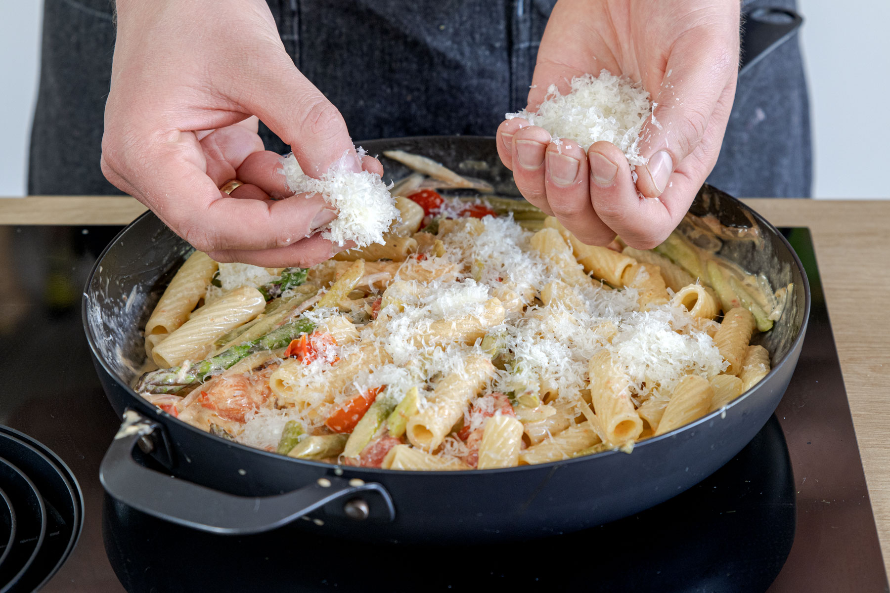Parmesan zur Pasta mit grünem Spargel geben