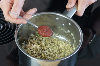 Tomatenmark zu den Gemüsewürfeln geben