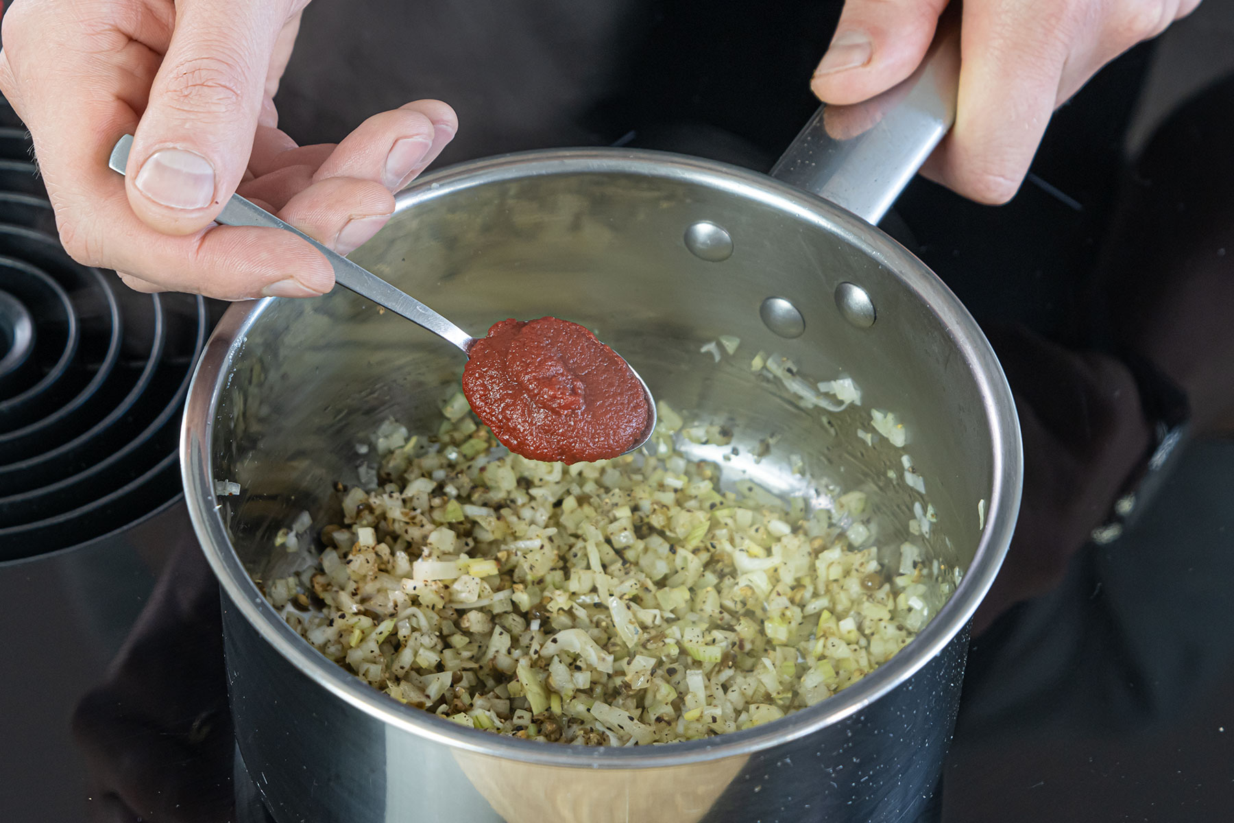 Tomatenmark zu den Gemüsewürfeln geben