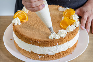 Deko auf der Quark-Sahne-Torte mit Mandarinen platzieren