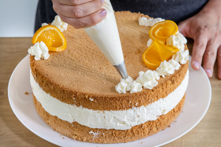 Deko auf der Quark-Sahne-Torte mit Mandarinen platzieren