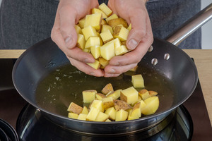 Kartoffeln in die Pfanne mit geschmolzenem Butterschmalz geben