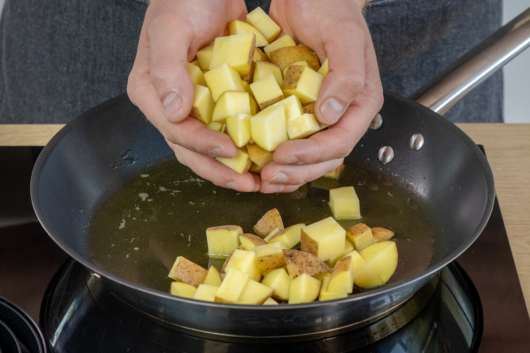 Kartoffeln in die Pfanne mit geschmolzenem Butterschmalz geben