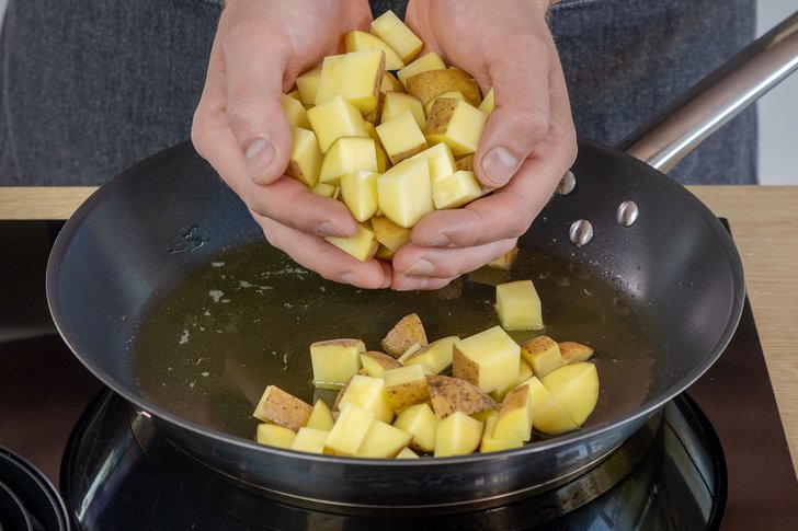 Kartoffeln in die Pfanne mit geschmolzenem Butterschmalz geben