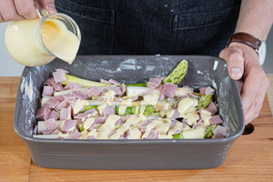 Sauce Hollandaise über das schnelle Spargelgratin gießen